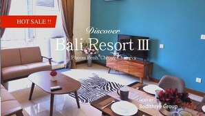 Un salon moderne comprenant un canapé, une table basse, un téléviseur et un coin repas agrémenté d’un tapis à motifs zébrés.