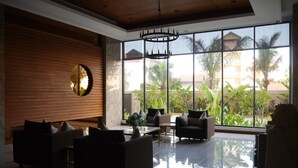 Un hall d’entrée spacieux au design moderne, agrémenté d’un grand lustre, de sièges confortables et de larges fenêtres offrant une vue sur l’extérieur.
