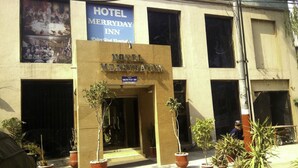 En bygning med et skilt, der viser "Hotel Merryday Inn".