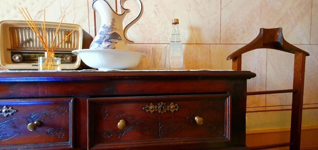 Une commode en bois avec des tiroirs et un vase.