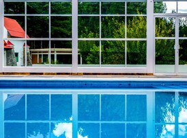 Una piscina techada, sillones reclinables de piscina