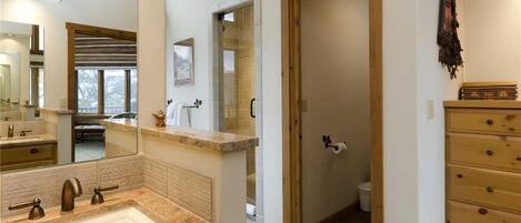 Un baño con un espejo grande, un lavabo y un armario de madera.