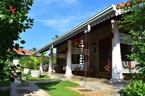 A traditional house with a covered porch, columns, and a decorative hanging ornament.