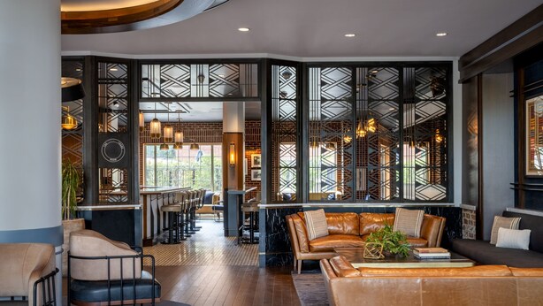 Un interior moderno con una zona de estar, un bar y una escalera.