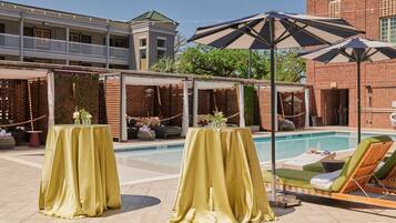 Relax by the pool with a clear view, lounge chairs, and shaded tables.