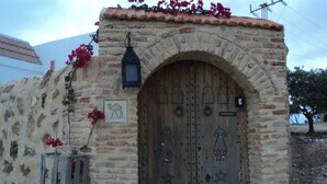 A stone building with a large wooden door, a lantern, and a camel symbol on the wall. - Luxury Home With Unique Gulf View Of Hammamet (Hammamet)