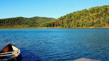 A calm lake with a dock and a small boat.