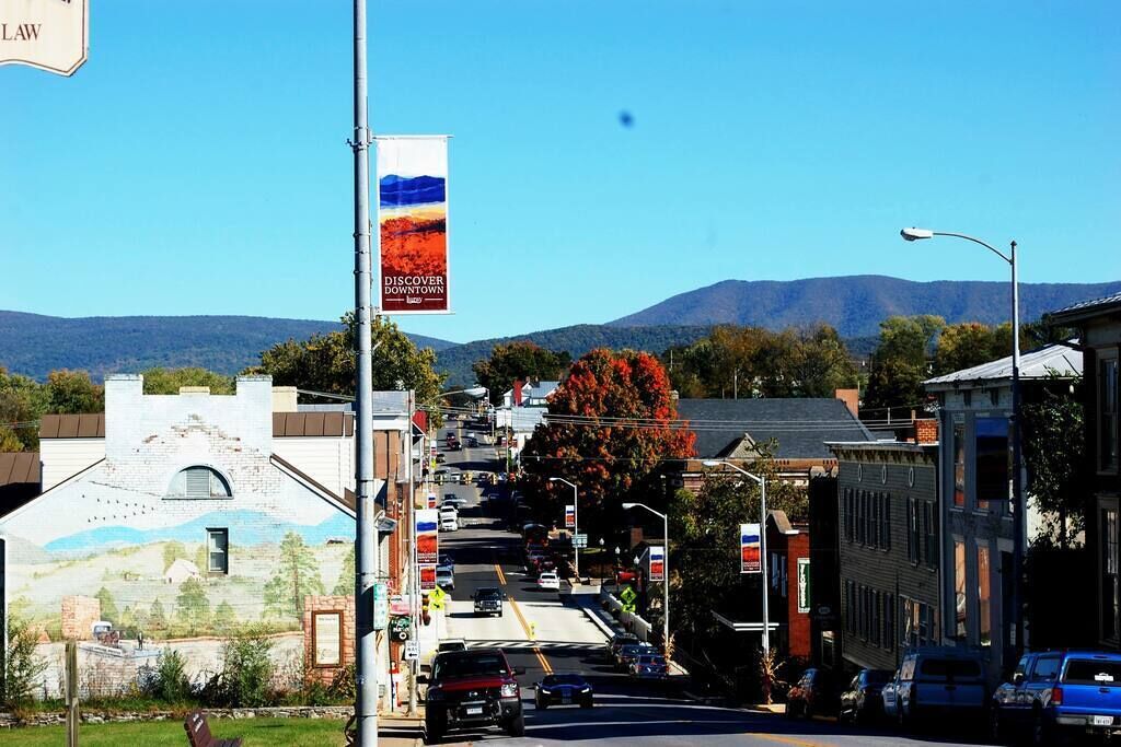 Une vue de rue avec des bâtiments, des voitures et une banderole faisant la promotion d’un quartier du centre-ville.