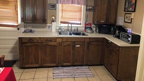 A kitchen with wooden cabinets, a sink, a microwave, and a toaster. - Steve & Katie Riley Guest House, Breaux Bridge, 2 Bd, 1.5 Ba. Welcome!  Sleeps 6 (Breaux Bridge)