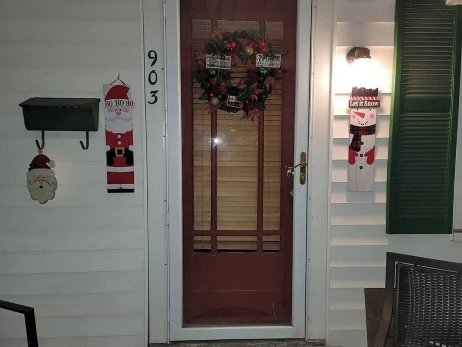 A front door with a Christmas wreath, a 'HO HO HO' sign, and a 'Let it Snow' sign.