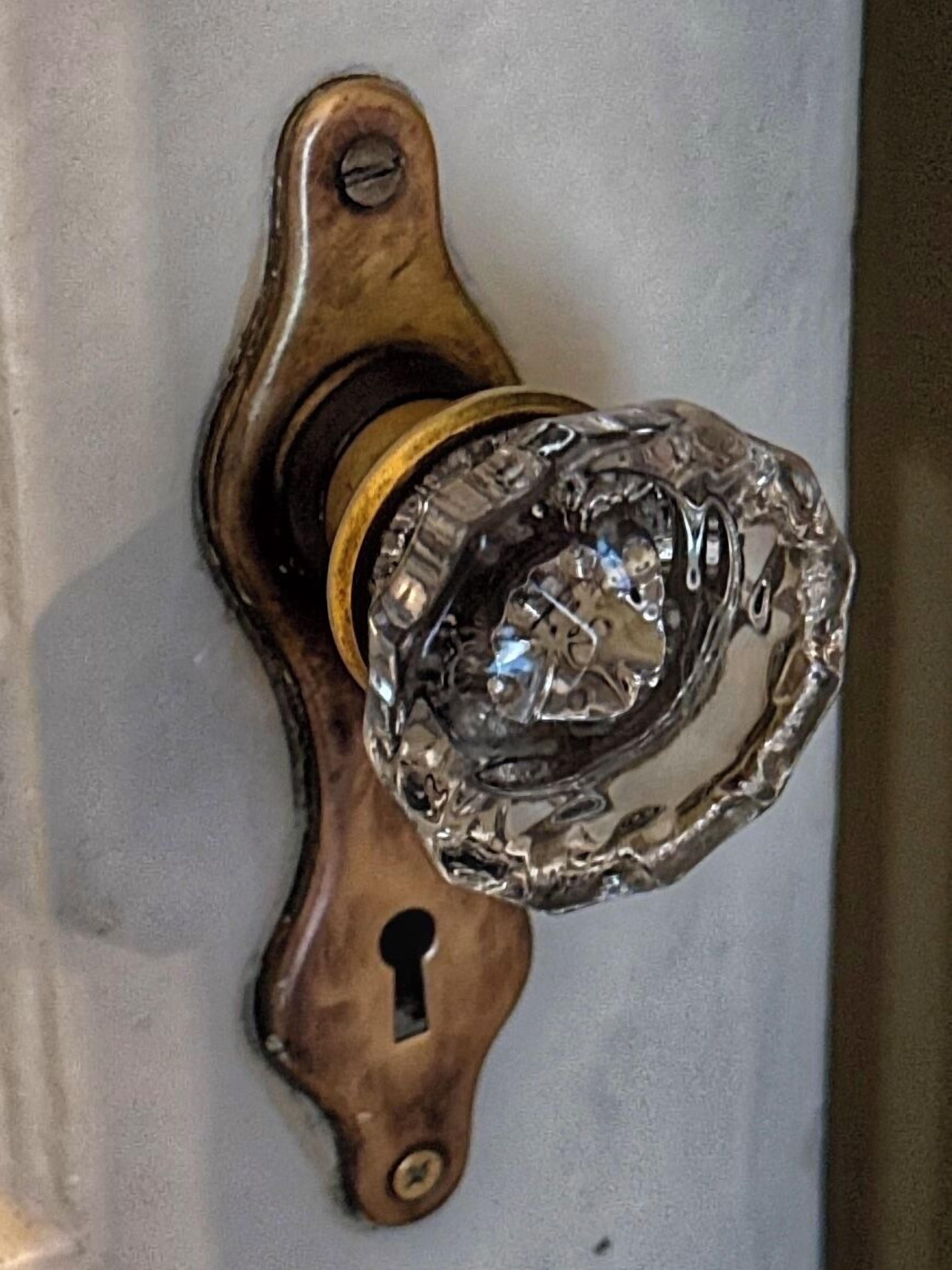 A door handle with a keyhole and a decorative glass knob.