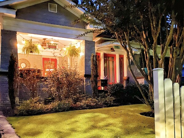 A house with a well-maintained lawn, a porch with a chair, and a visible number '915' on the front.
