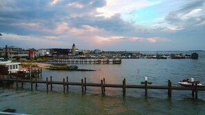 A marina with boats docked, a pier extending into the water, and buildings in the background. - Middle of Dewey ,On the Bay, Close to the Beach  (Dewey Beach)