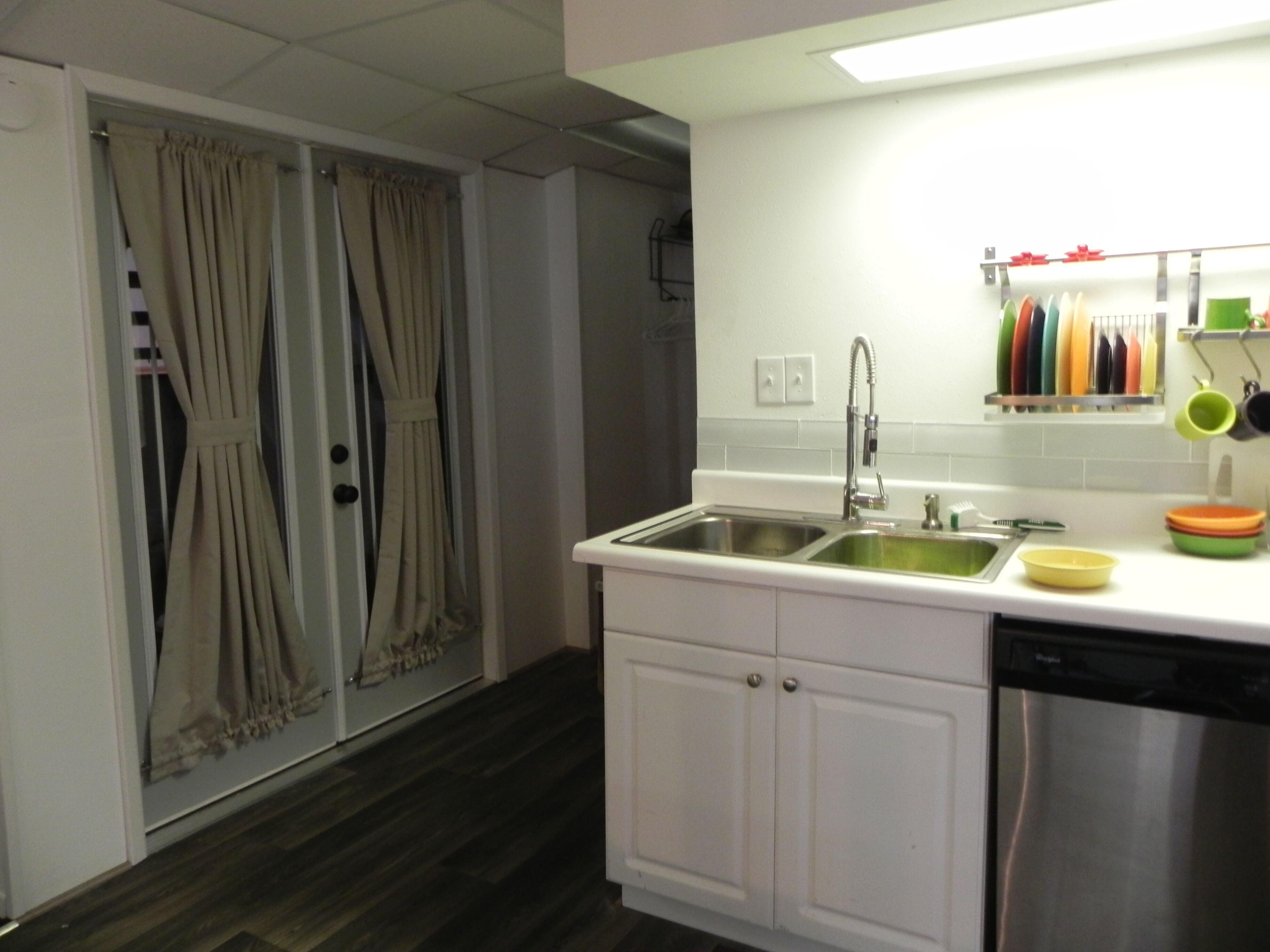A kitchen with white cabinets, a stainless steel dishwasher, and a sink.