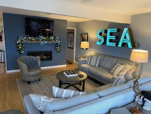 A modern living room with a fireplace, a sofa, a coffee table, and a TV.