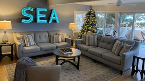 A living room with two sofas, a coffee table, and a Christmas tree.