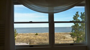 A window with a view of a beach and ocean.