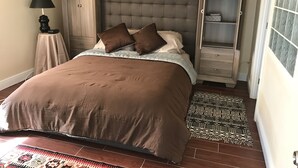 A bedroom with a large bed, a nightstand, a lamp, a wardrobe, and a window with a view. - ON the Beach, 2nd Floor, Elevator, Heated swimming pool and Spa, Freshly painted (Longboat Key)