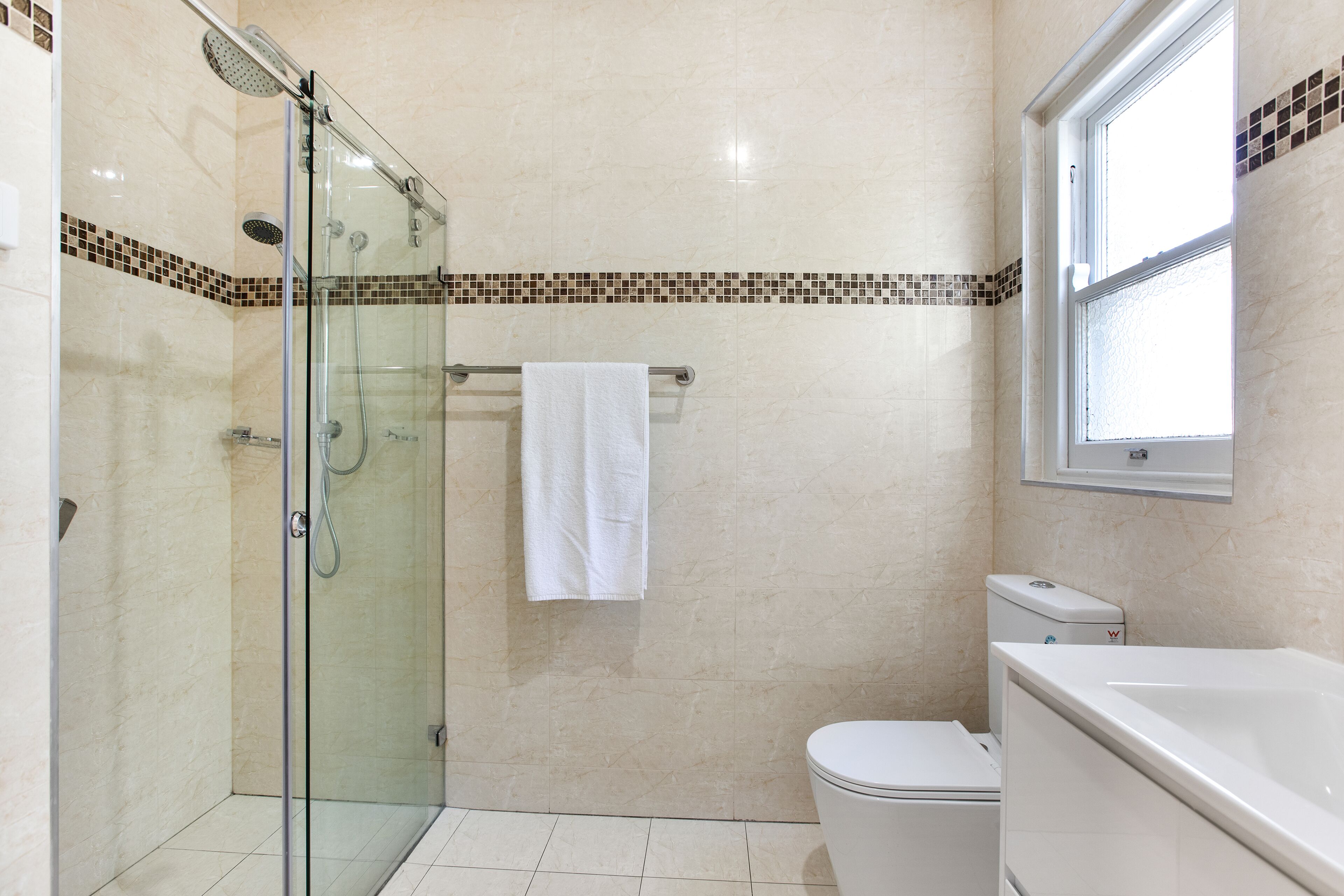Een badkamer met een douchecabine, toilet en ligbad.