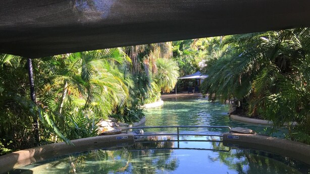 A hot tub surrounded by lush greenery, with a wooden deck and lounge chairs. - Golf Course Apartment/Within Trinity Links Resort/ Selfcontained (White Rock)