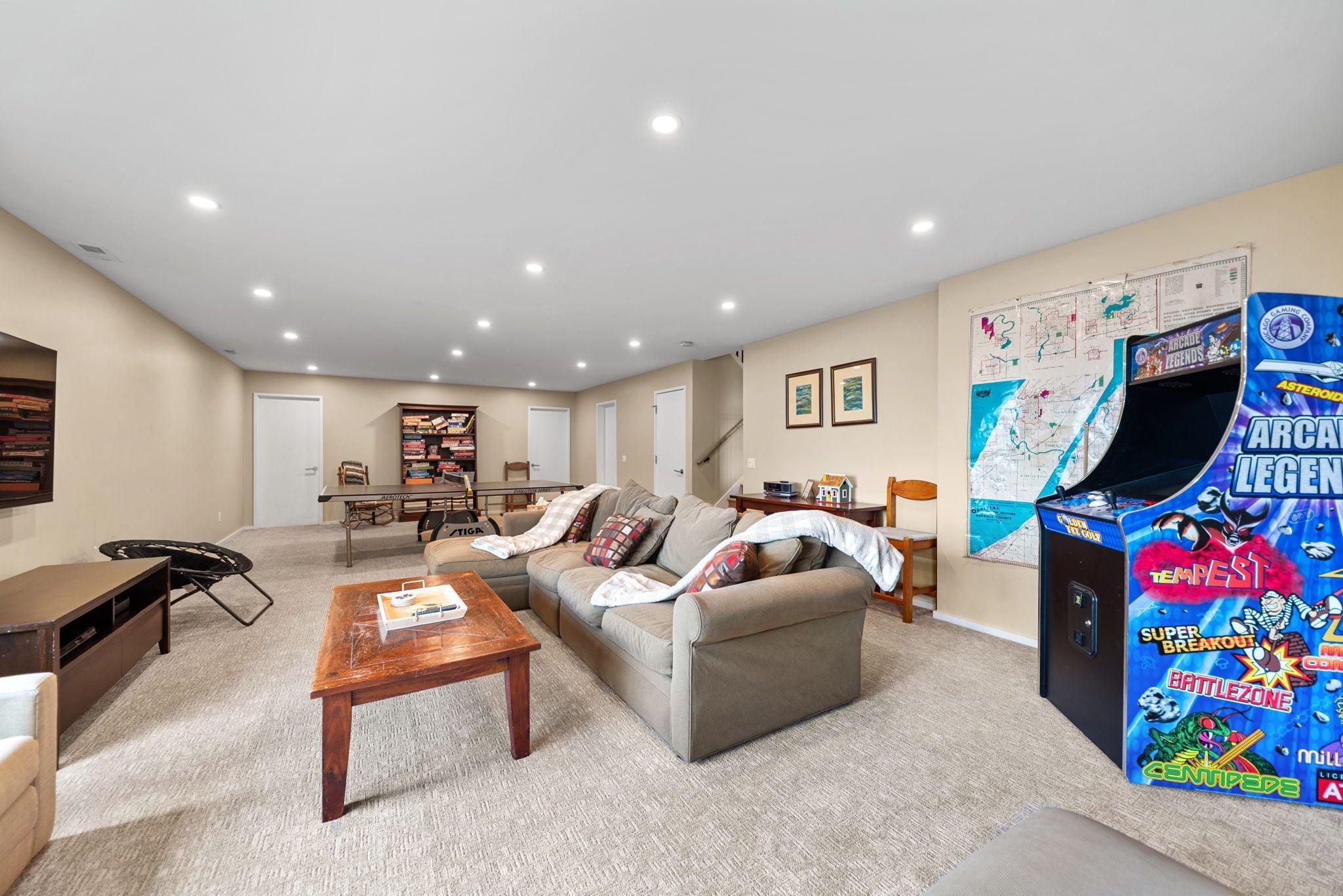 A living room with a sofa, coffee table, and a game console.
