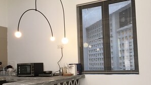 Una cocina moderna con barra, aire acondicionado y una ventana con persianas.