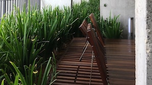 Una estructura de concreto con vigas de metal y un banco de madera.