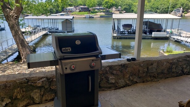 A Weber Spirit grill with a view of a lake and docked boats. - 10MM Lake Getaway - 3 Br, 2 Bath - Franky & Louie's Cove! (Sunrise Beach)