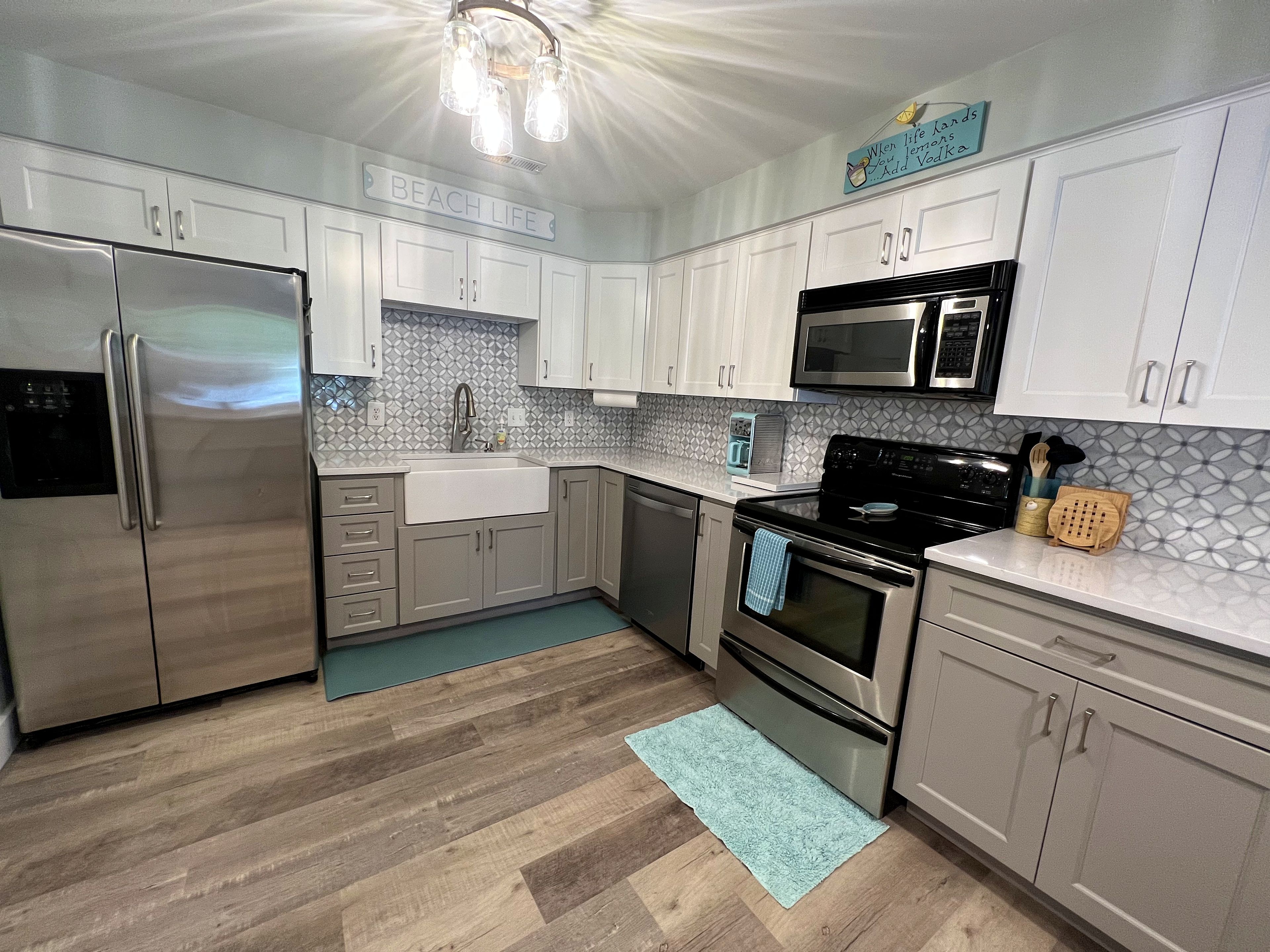 Una cucina moderna con elettrodomestici in acciaio inossidabile, mobili bianchi e un backsplash decorato.