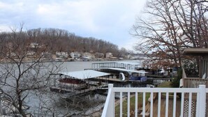 A waterfront property with a dock, outdoor seating area, and a view of the river and surrounding houses. - 10MM Lake Getaway - 3 Br, 2 Bath - Franky & Louie's Cove! (Sunrise Beach)