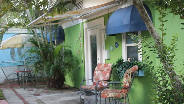 A patio area with outdoor furniture, including two chairs and a table, and a small lamp. -  Country  Cottage Home (Bradenton)