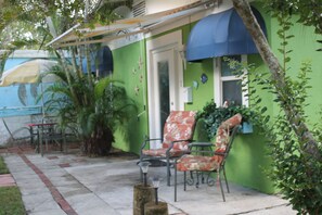 A patio area with outdoor furniture, including two chairs and a table, and a small lamp. - Country Cottage Home (Bradenton)