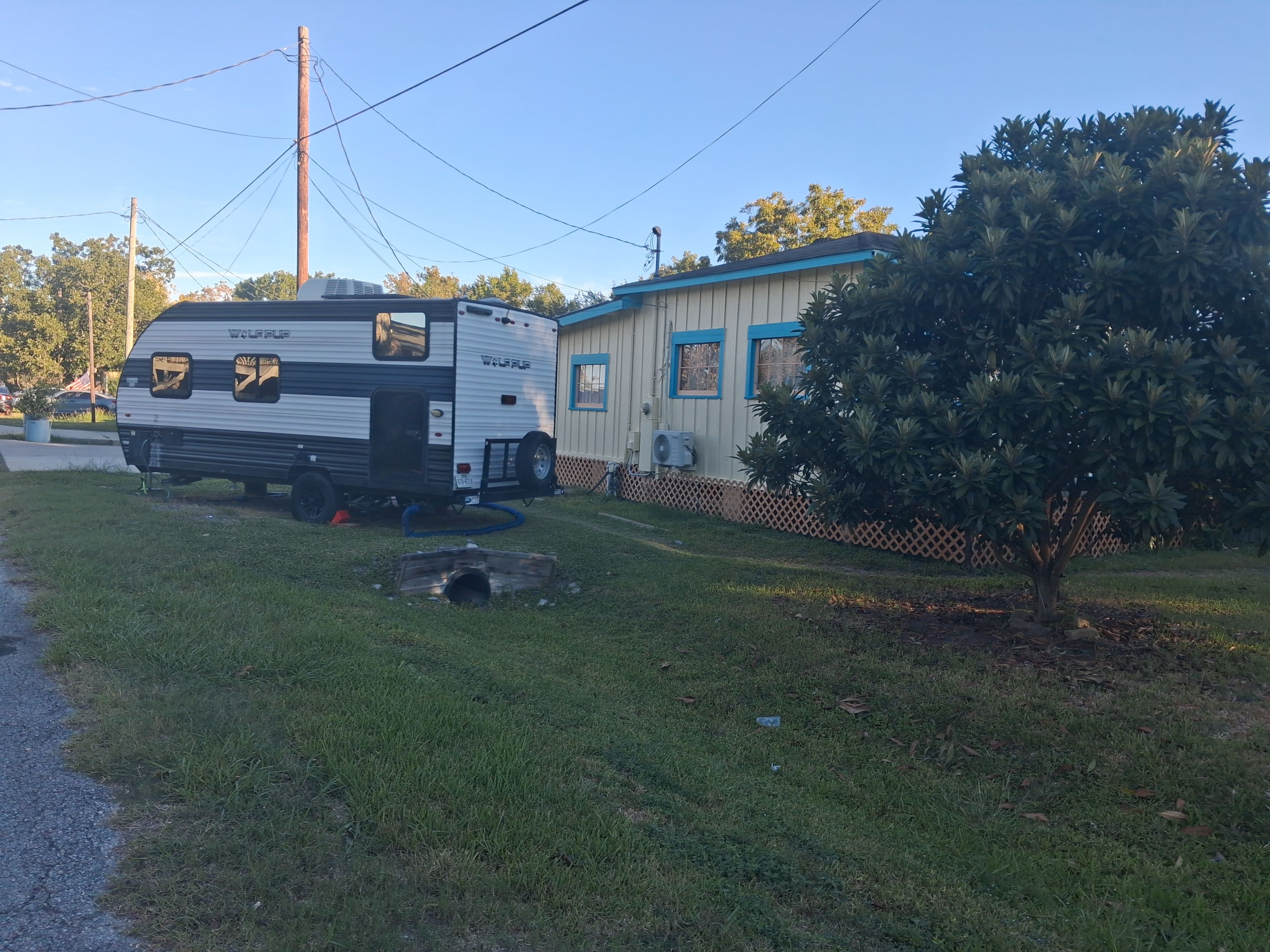 A recreational vehicle (RV) parked in a grassy area with a small shed nearby.
