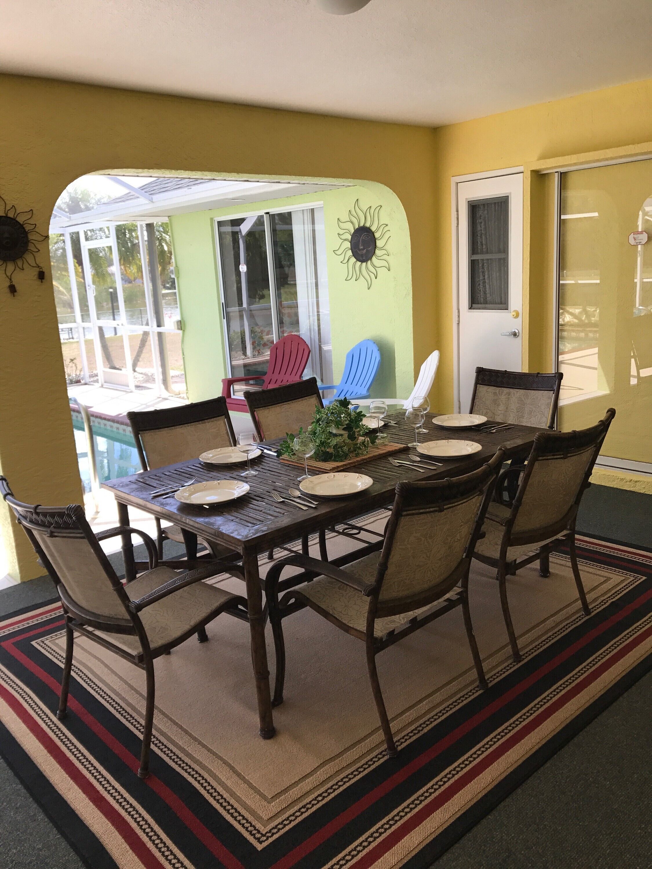 Un coin repas avec une table dressée pour six personnes, entourée de six chaises.