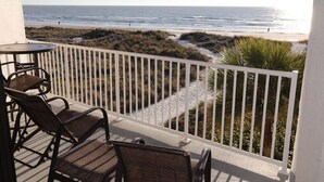 Ein Balkon mit Blick auf Strand und Meer.