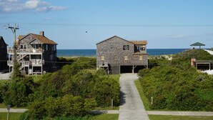 A coastal property with a pathway leading to a house with a garage.