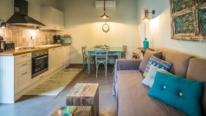 A compact living space with a kitchenette, dining area, and seating area. - Charming and traditional small stone house. (Corfu)
