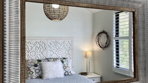 A bedroom with a bed, a nightstand, a lamp, a window with blinds, and a decorative wreath on the wall. - Panoramic Bay Views - Pet friendly & only a  5 minute stroll to town (Dunsborough)