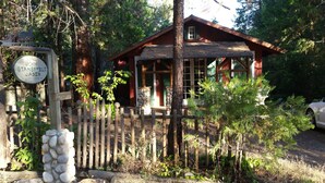 A cabin with a stone wall entrance, surrounded by a wooden fence and trees. -  11 miles to Kings Canyon Natl Park with Wi-Fi (Miramonte)
