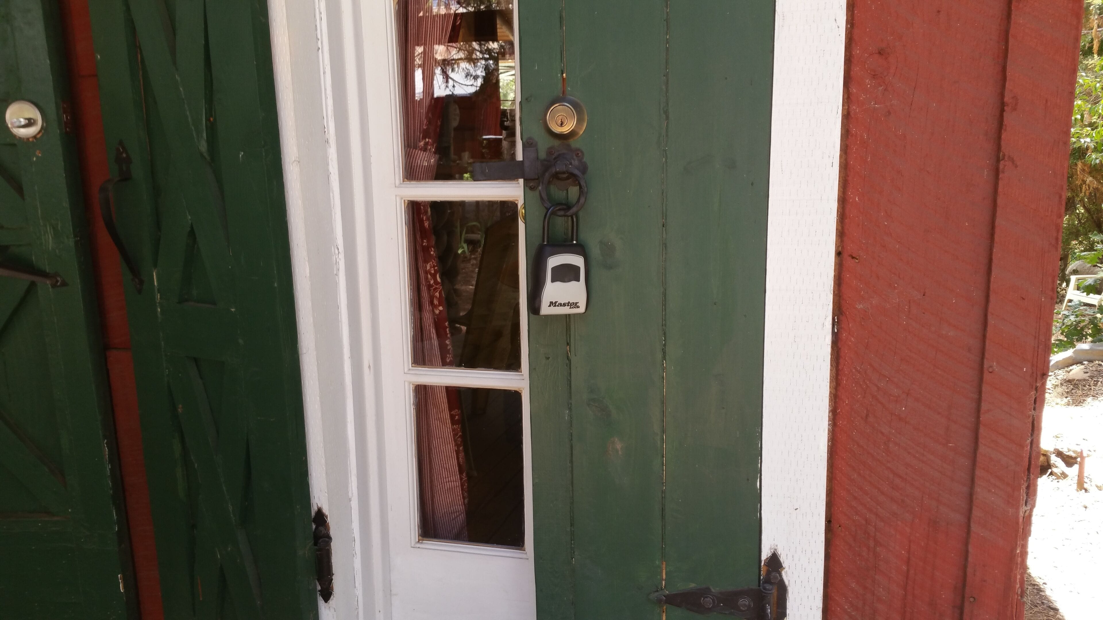 A green door with a white window and a doorbell.