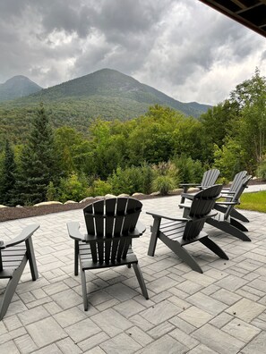 Outdoor seating with a view of mountains and greenery.