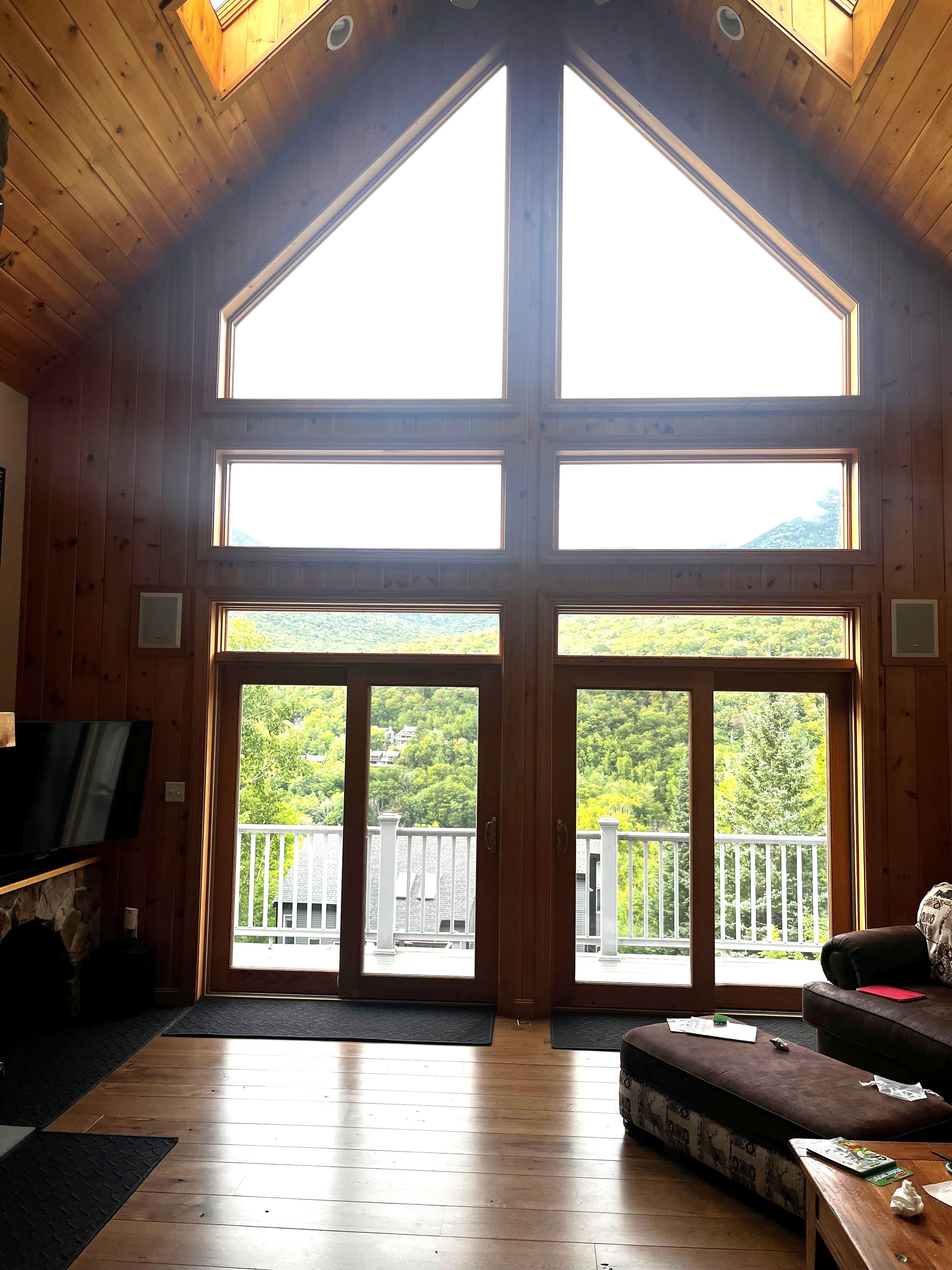 Un intérieur en bois avec une grande fenêtre et un balcon.