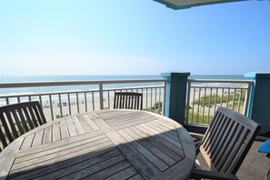 A wooden table and chairs on a balcony with a view of the beach and ocean. - Huge 5 Bedroom Oceanfront Condo, Huge Balcony, Amazing Views, 3 Pools, Jacuzzi! (Myrtle Beach)