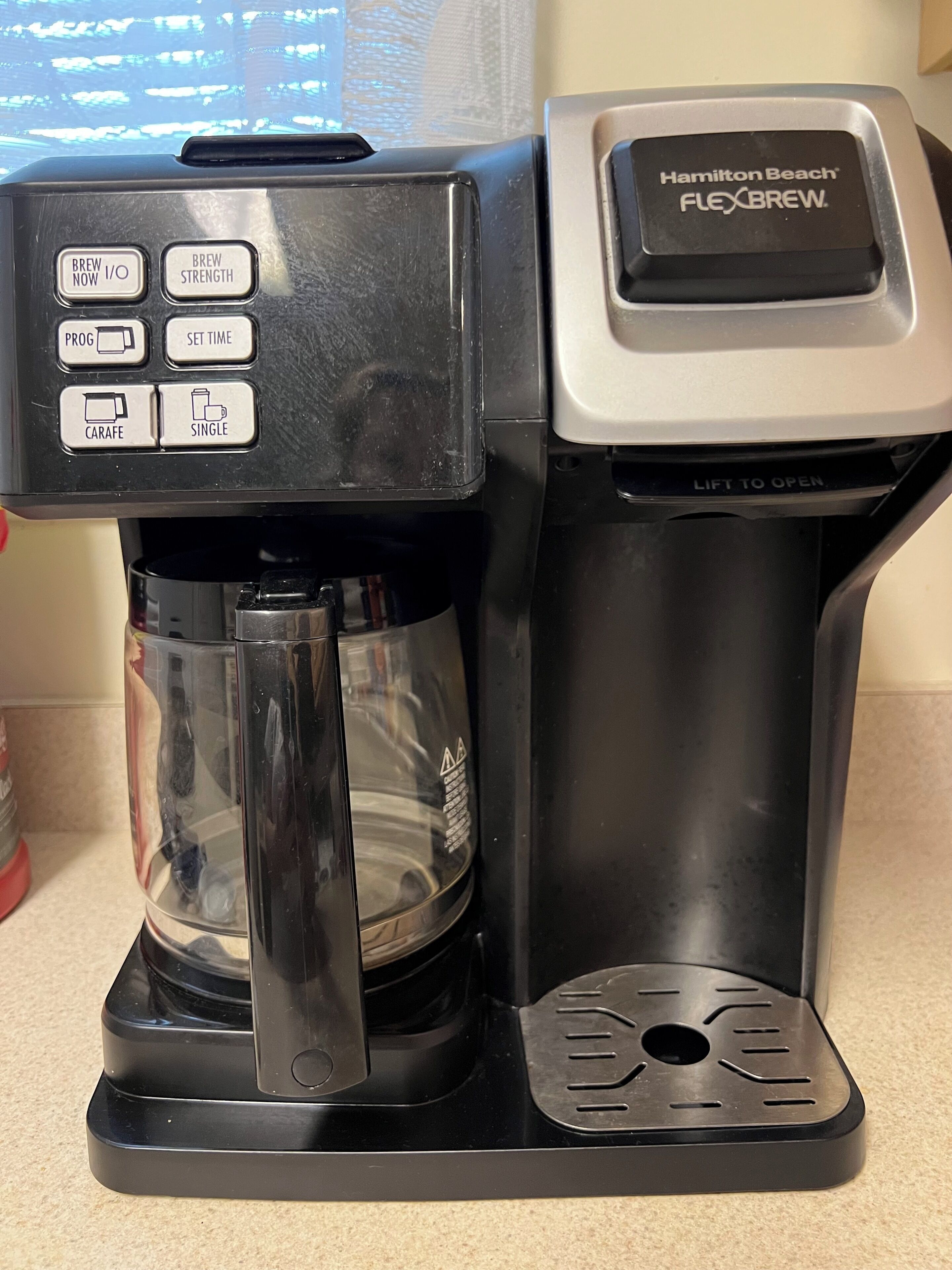 Une machine à café Hamilton Beach Flexbrew, dotée d’une verseuse et d’un bac de récupération.