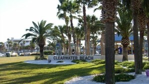 A sign for 'Clearwater Beach' with palm trees and a grassy area in the foreground. - Harborview Grande, Clearwater Beach - Private Balcony, Walk to It All (Clearwater Beach)
