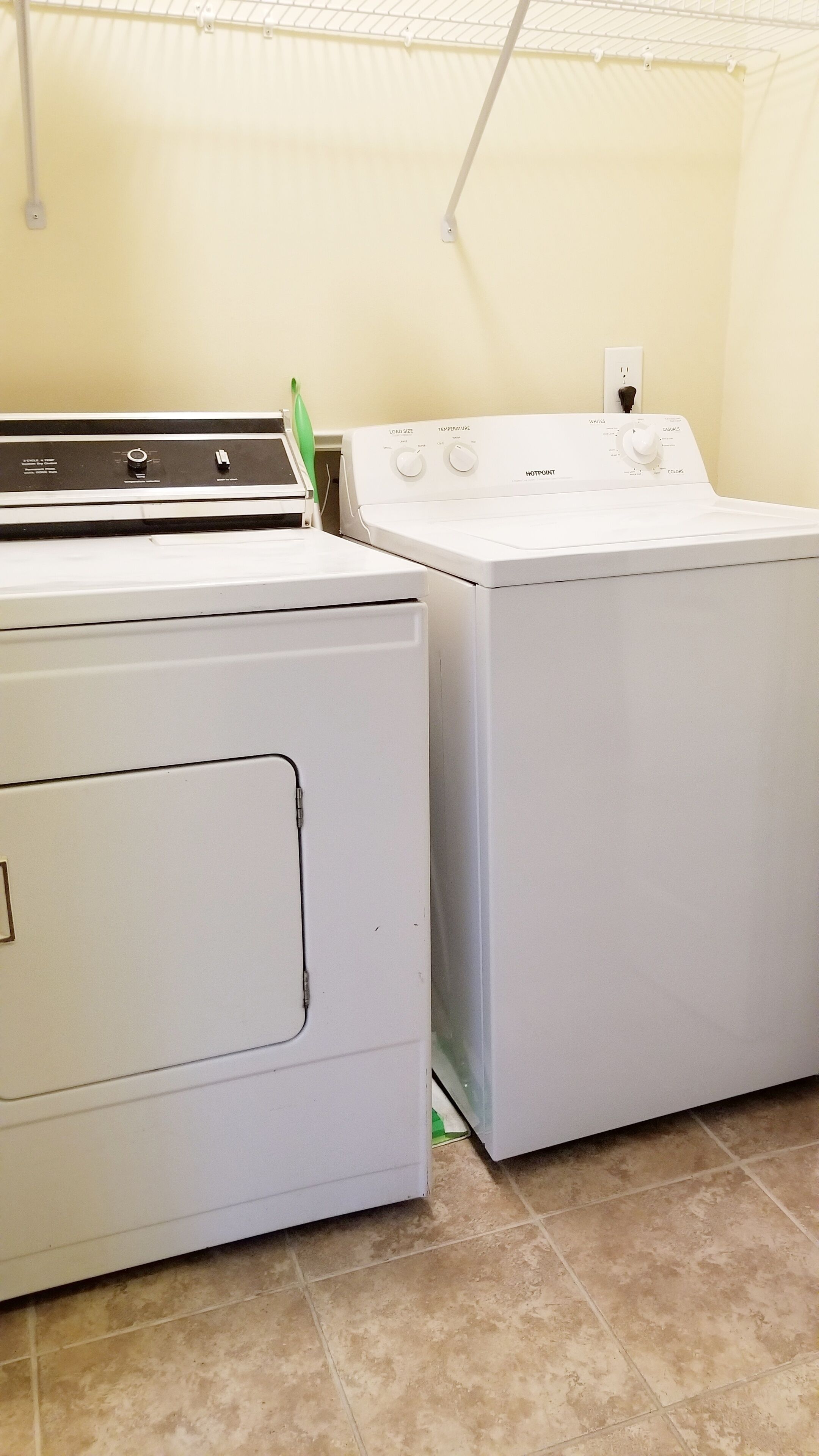 A laundry room with two white washing machines and a dryer.