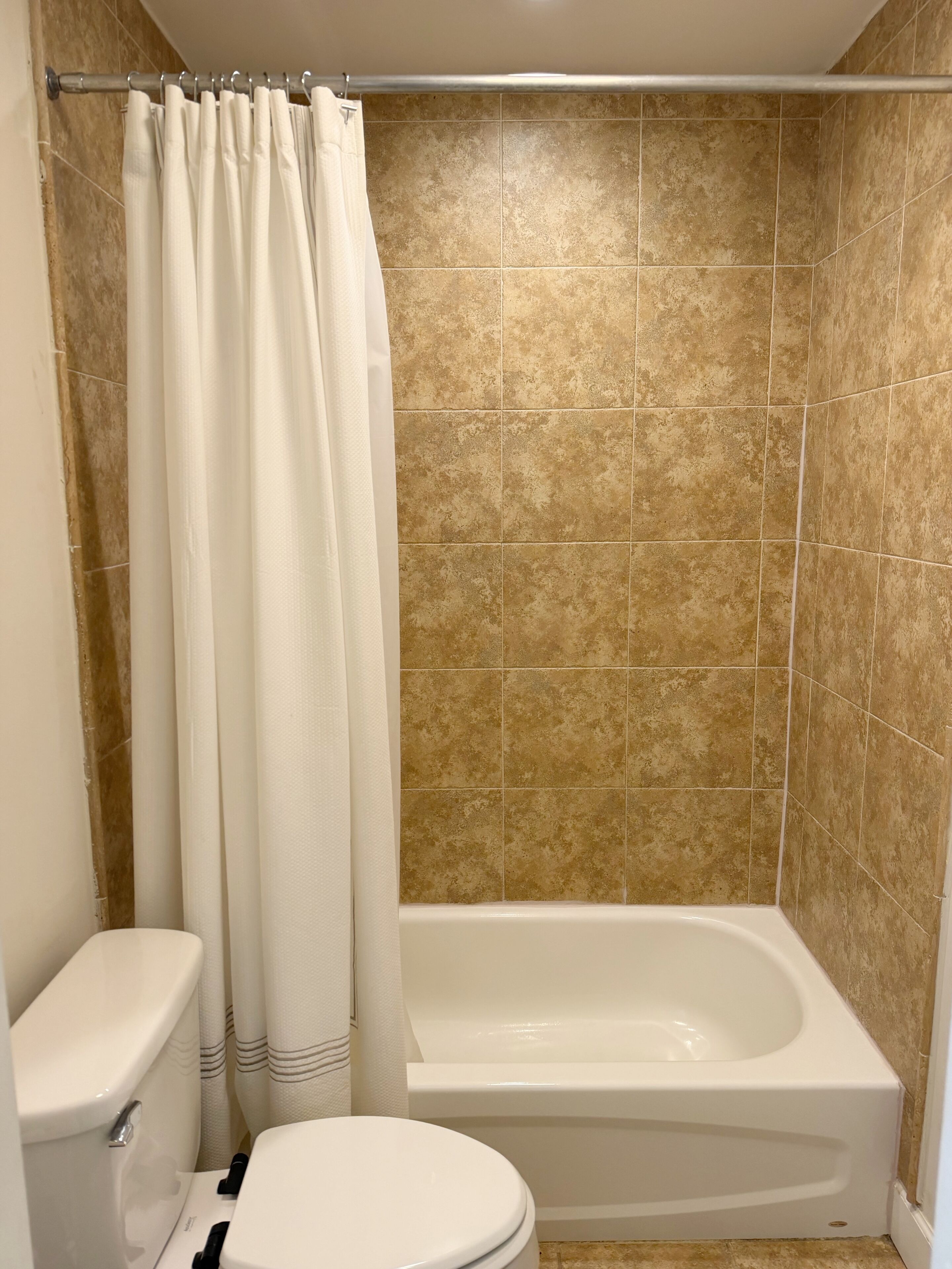 Ein Badezimmer mit Badewanne, Toilette und Duschvorhang.