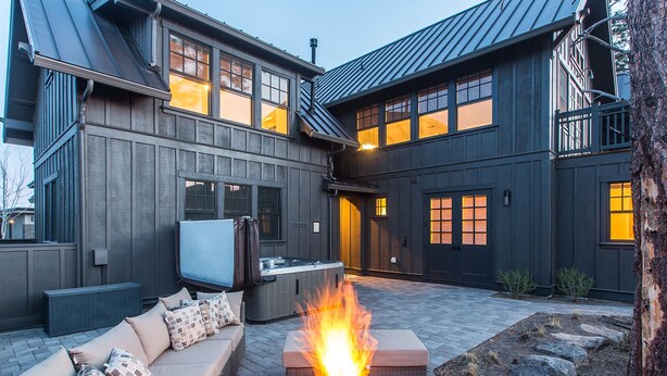 A modern house with a patio area featuring a fire pit, outdoor seating, and a large TV screen. - Bring bikes + SUP and have summer Bend fun! 24-hr staff ~ tons of room ~ resort  (Bend)