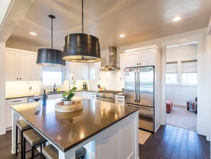 Enjoy cooking in this well-lit kitchen with a central island, sink, and stainless steel appliances.