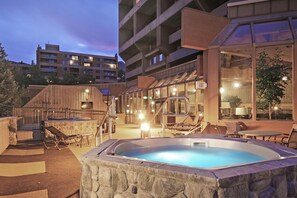 Relax by the pool surrounded by lounge chairs and a small table, with access to additional facilities via the staircase.